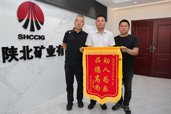 1722300000100147.jpeg 图为:刘鑫(中)接管锦旗.JPG